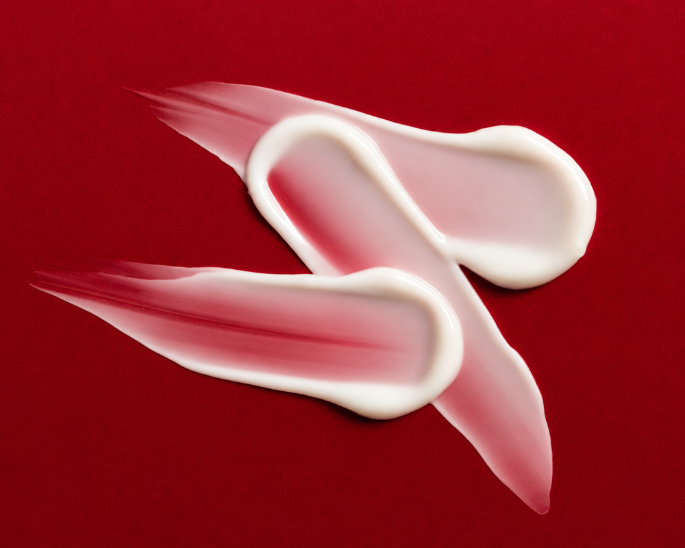 Red tube of 'The Everything Balm' by Third Shift on a red background